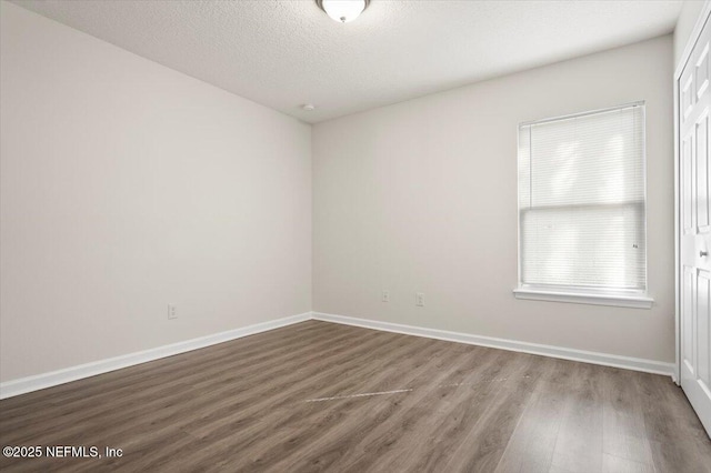 spare room with wood-type flooring and a textured ceiling