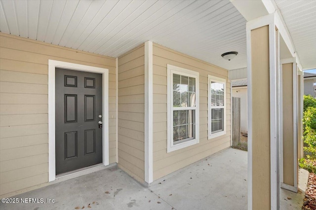 view of exterior entry featuring covered porch