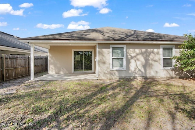 rear view of property featuring a patio area and a lawn