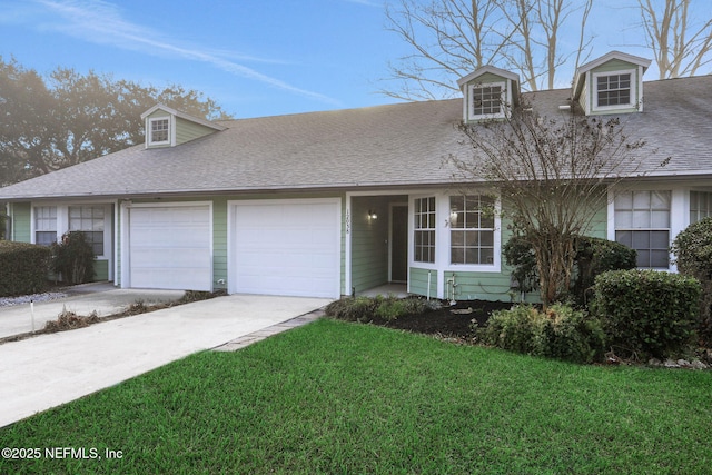 view of front of property with driveway, a front lawn, an attached garage, and a shingled roof