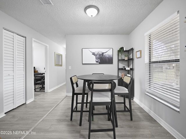 dining room featuring hardwood / wood-style floors and a textured ceiling