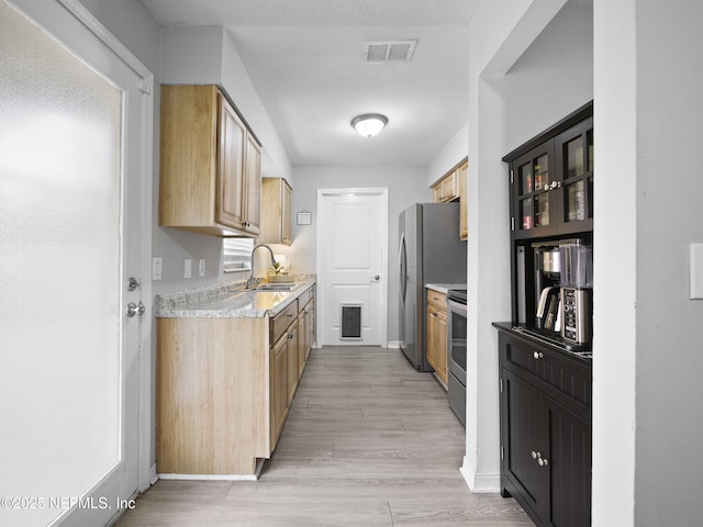 kitchen featuring sink, stainless steel appliances, and light hardwood / wood-style floors