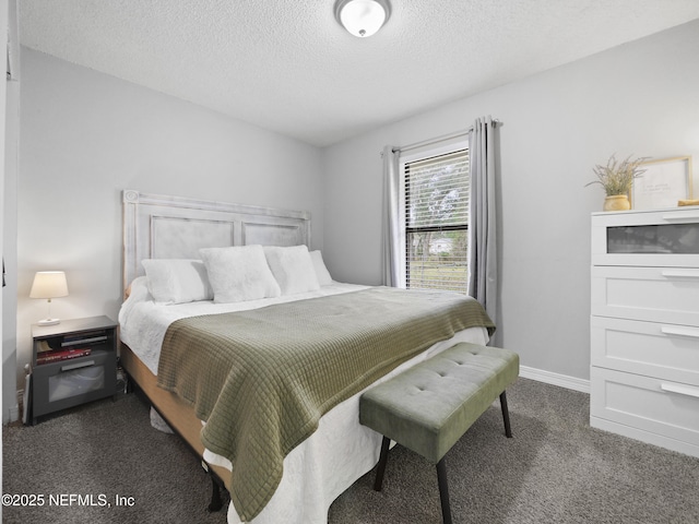 bedroom featuring a textured ceiling and dark colored carpet