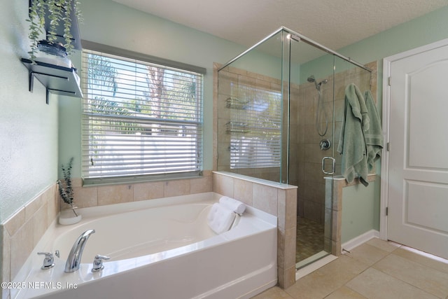 bathroom featuring a stall shower, tile patterned flooring, a textured ceiling, and a bath