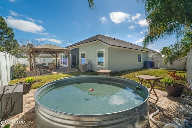 view of pool with a gazebo, a patio, a fenced backyard, and central air condition unit