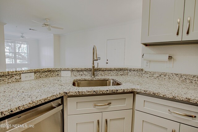 kitchen with sink, light stone counters, dishwasher, white cabinets, and ornamental molding