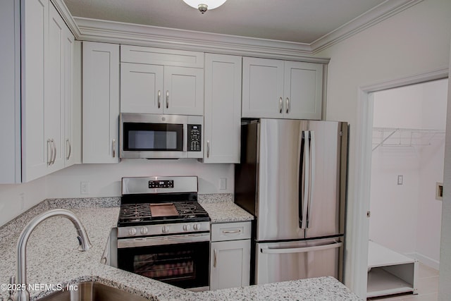 kitchen featuring appliances with stainless steel finishes, sink, light stone countertops, and ornamental molding