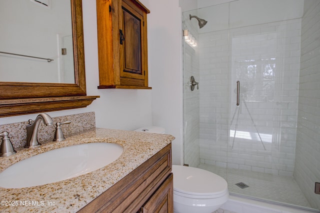 bathroom with toilet, vanity, and walk in shower