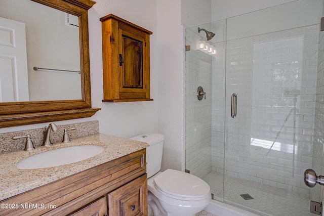 bathroom with vanity, a shower with shower door, and toilet