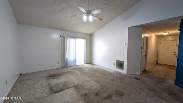 carpeted empty room featuring ceiling fan, vaulted ceiling, and a textured ceiling