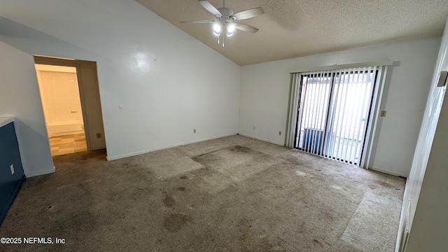 carpeted spare room with vaulted ceiling, ceiling fan, and a textured ceiling