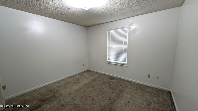 carpeted empty room with a textured ceiling