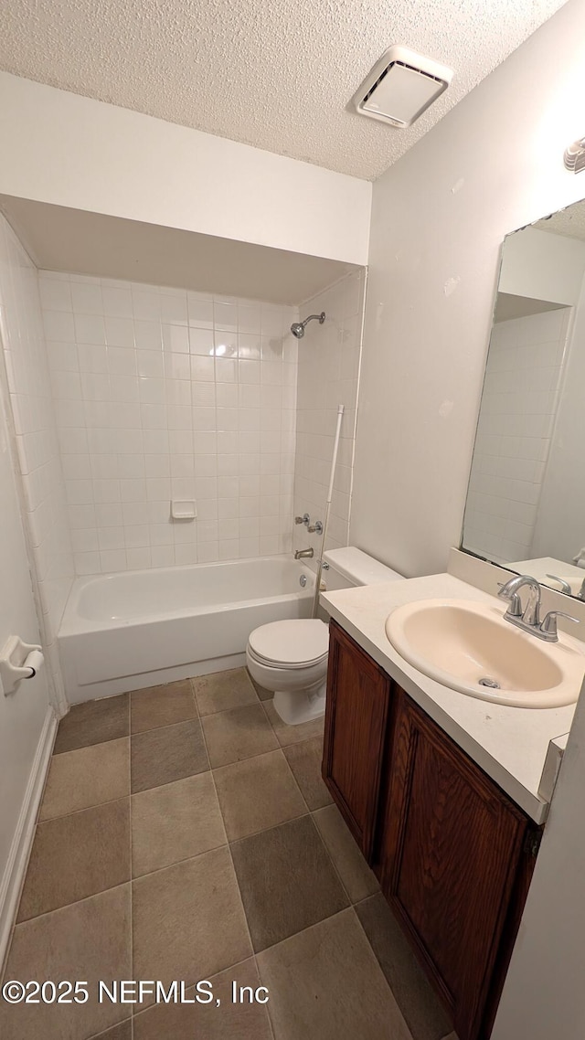 full bathroom featuring tiled shower / bath, vanity, toilet, and a textured ceiling