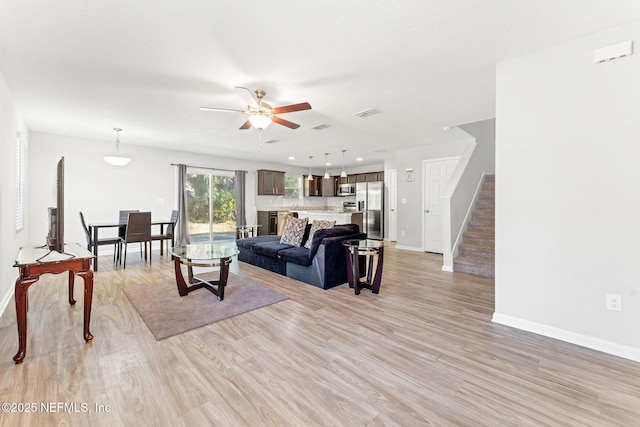 living room featuring ceiling fan and light wood-type flooring