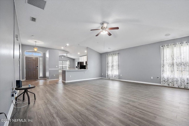 unfurnished living room with vaulted ceiling, ceiling fan, hardwood / wood-style floors, and a wealth of natural light