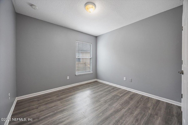 unfurnished room featuring a textured ceiling and dark hardwood / wood-style flooring