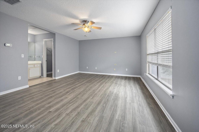 spare room with ceiling fan, dark hardwood / wood-style floors, and a textured ceiling