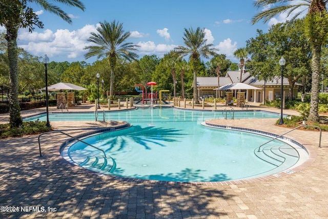 view of swimming pool with a patio area and a water slide