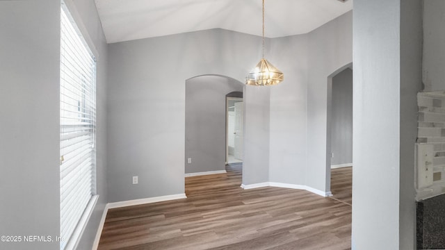 unfurnished dining area with wood-type flooring, lofted ceiling, and an inviting chandelier