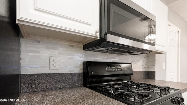 kitchen featuring tasteful backsplash, black gas stove, and white cabinets