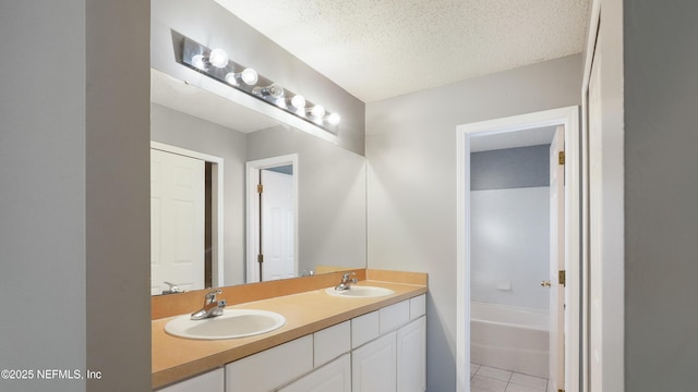 bathroom with vanity, a tub, tile patterned floors, and a textured ceiling