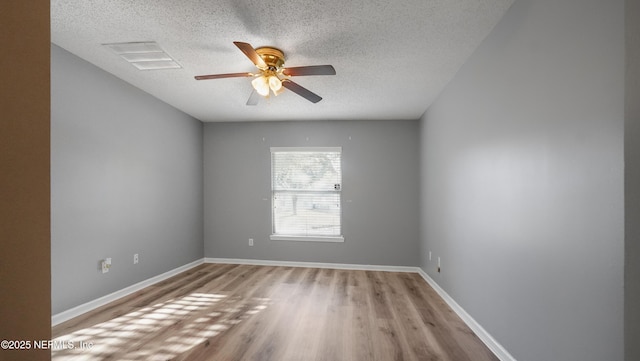 empty room featuring ceiling fan, light hardwood / wood-style floors, and a textured ceiling