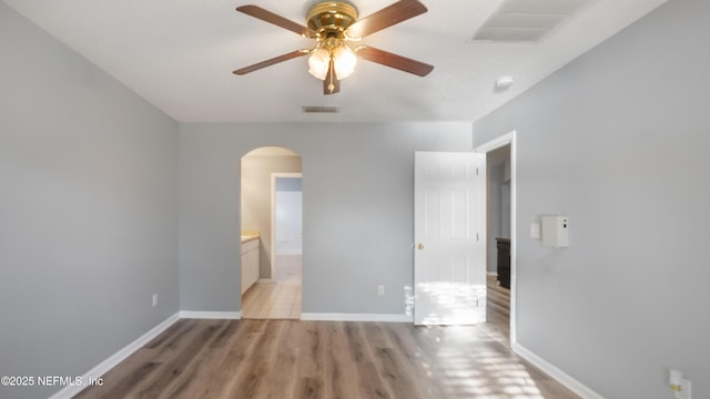 unfurnished bedroom featuring ceiling fan, ensuite bathroom, and light hardwood / wood-style flooring