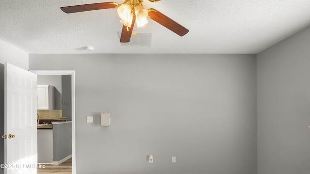 spare room with light hardwood / wood-style floors and a textured ceiling