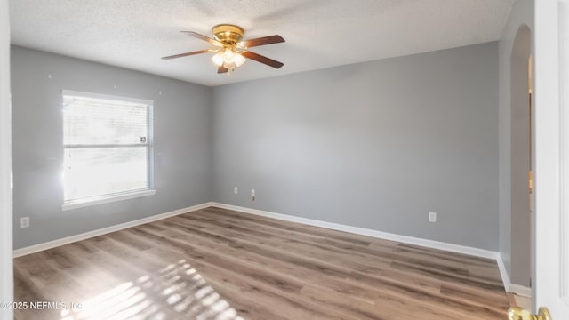 unfurnished room featuring ceiling fan, wood-type flooring, and a textured ceiling