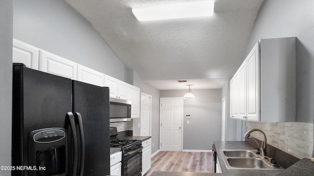 kitchen featuring white cabinets, sink, hanging light fixtures, and black appliances