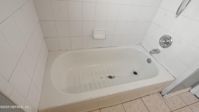 bathroom with tile patterned flooring and a bathtub