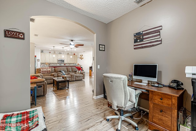 office featuring ceiling fan, a textured ceiling, and light wood-type flooring