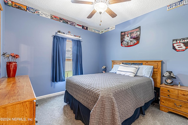 bedroom with ceiling fan, carpet flooring, and a textured ceiling