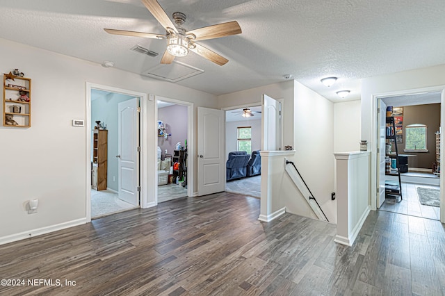 empty room with ceiling fan, dark hardwood / wood-style floors, and a textured ceiling