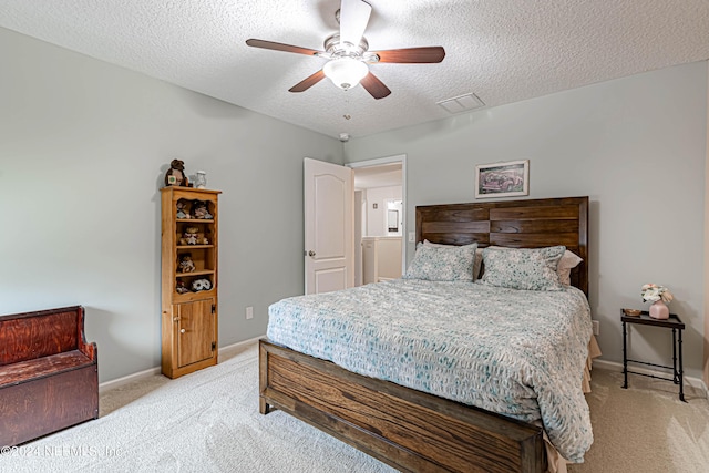 carpeted bedroom with ceiling fan and a textured ceiling