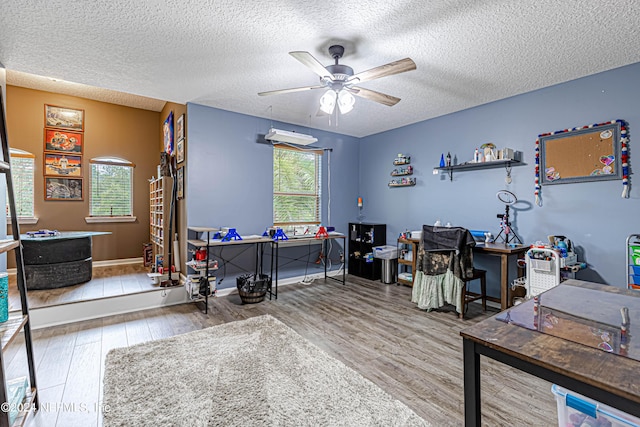 office area featuring ceiling fan, light hardwood / wood-style floors, and a textured ceiling