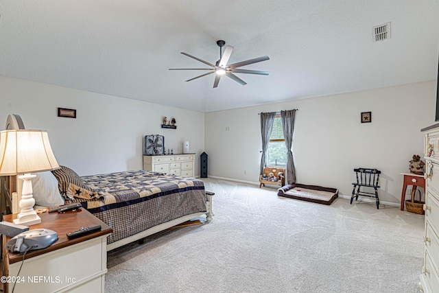 carpeted bedroom featuring ceiling fan and a textured ceiling