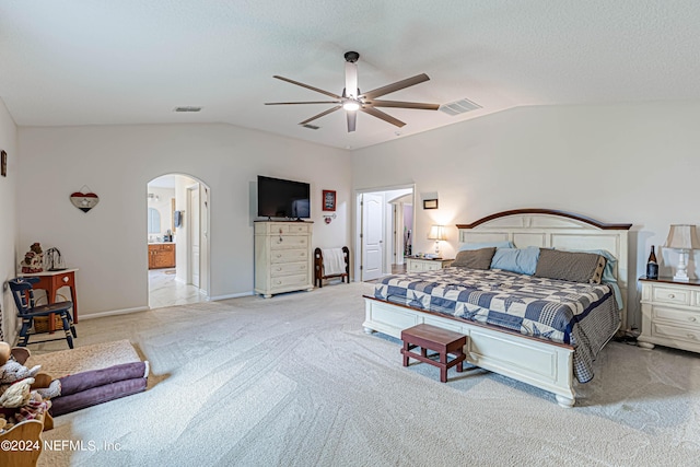 bedroom featuring connected bathroom, light colored carpet, vaulted ceiling, a textured ceiling, and ceiling fan