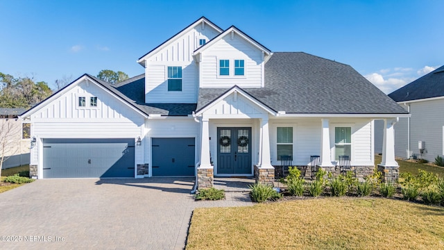 view of front facade featuring a garage, covered porch, and a front yard