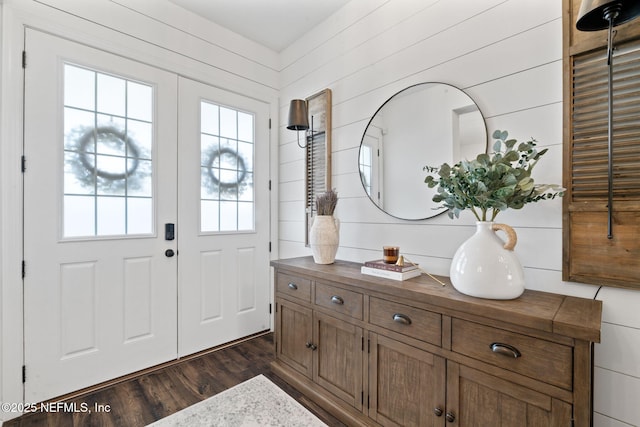 entryway with dark wood-type flooring and wood walls