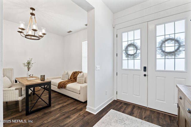 foyer with a notable chandelier and dark hardwood / wood-style floors