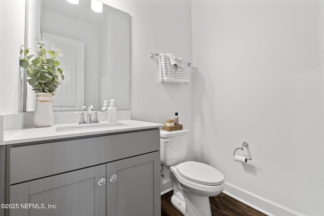 bathroom with hardwood / wood-style flooring, vanity, and toilet