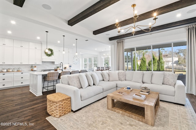 living room with beam ceiling, hardwood / wood-style floors, and a notable chandelier