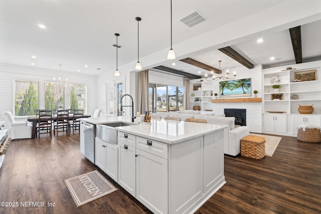 kitchen with sink, dishwasher, a kitchen island with sink, white cabinetry, and hanging light fixtures