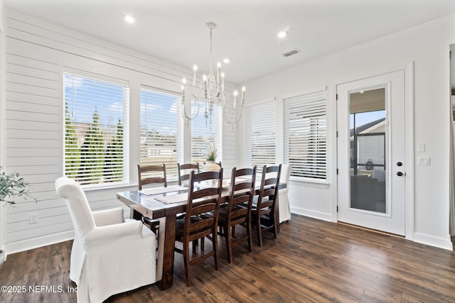 dining space with a notable chandelier and dark hardwood / wood-style floors