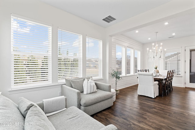 living room with a notable chandelier and dark hardwood / wood-style flooring