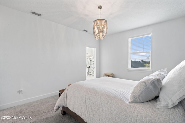 carpeted bedroom with a notable chandelier