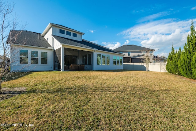 back of property featuring a sunroom and a yard