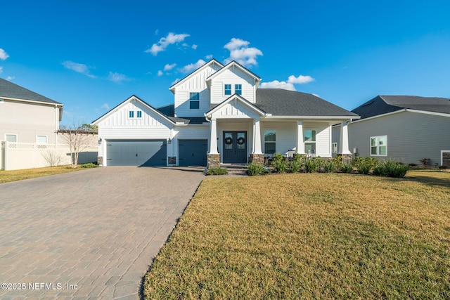 view of front of property with a garage, a front lawn, and covered porch