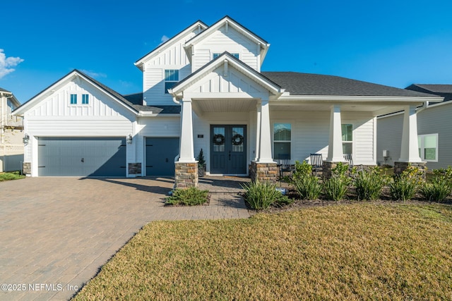 craftsman-style home featuring a porch, a garage, and a front yard